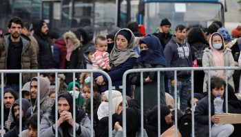Migrants who arrived on the island of Lesbos in the past four days, are seen at the port of Mytilene, as they wait to board a Greek navy ship, in Mytilene
